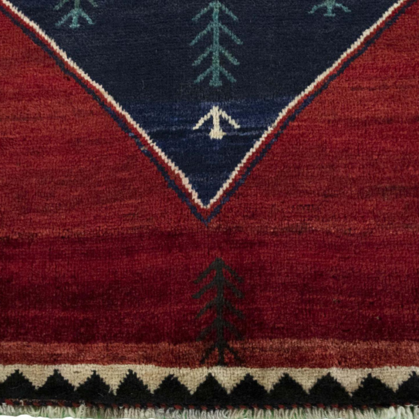 Hand-knotted Gabbeh rug in shades of red and blue with a geometric pattern.